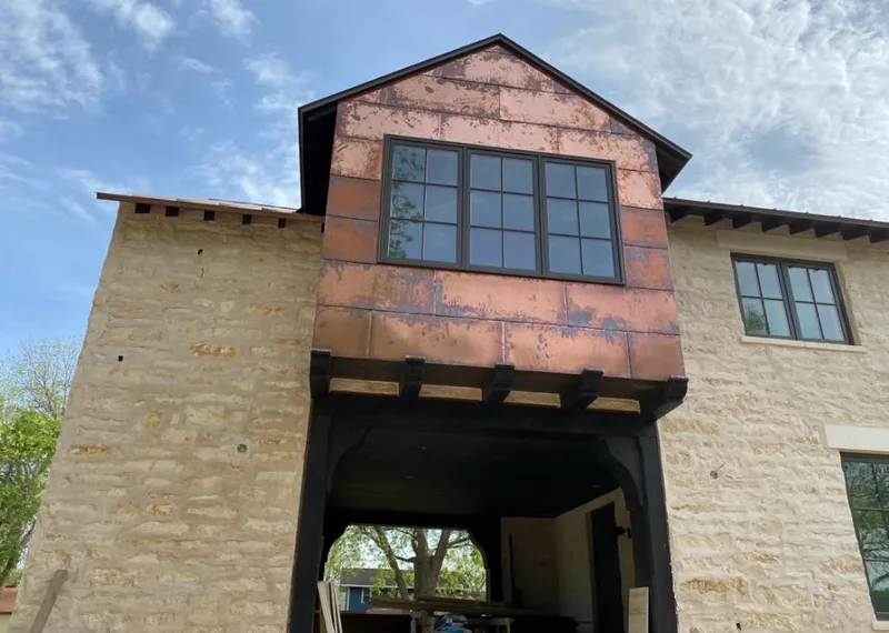 Copper metal panel facade on a stone building for Skylight Installation in Meredith